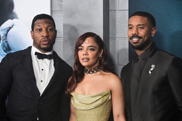 (FILES) In this file photo taken on February 27, 2023, (L-R) actor Jonathan Majors, actress Tessa Thompson, and actor-director-producer Michael B. Jordan arrive for the Los Angeles premiere of Creed III at the TCL Chinese Theater in Hollywood, California. - MGM's boxing drama "Creed III" scored an opening-round knockout the weekend of March 5, 2023, taking in an estimated $58.7 million to top North America's box office in one of the biggest debuts ever for a sports film. (Photo by Robyn BECK / AFP)