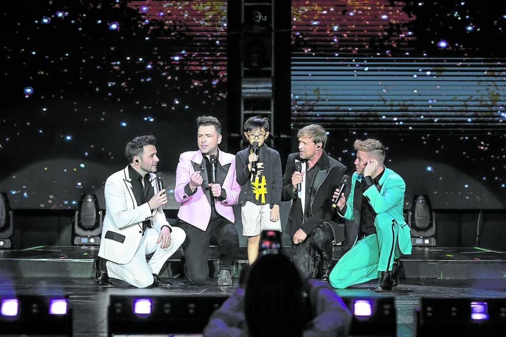 Westlife shares the stage with a young fan —PHOTOS BY MANUEL CHUA/WILBROS LIVE