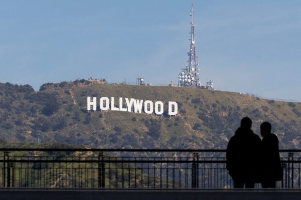 FILE PHOTO: People look out at the Hollywood sign in Hollywood, Los Angeles, California, U.S., March 9, 2023.  REUTERS/Mike Blake/File Photo