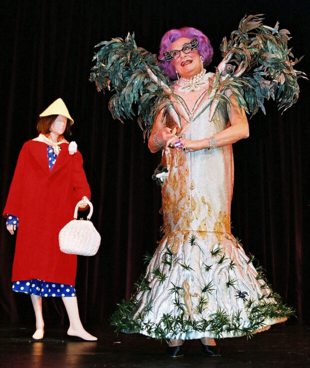 FILE PHOTO: Dame Edna Everage, a character portrayed by Australian comedian Barry Humphries, laughs while wearing an outfit adorned with toy koalas and eucalyptus tree branches, Melbourne. REUTERS/Stuart Milligan