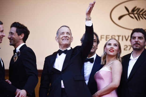 The 76th Cannes Film Festival -  Screening of the film "Asteroid City" in competition - Red Carpet Arrivals - Cannes, France, May 23,  2023. Cast member Tom Hanks gestures next to Scarlett Johansson and Adrien Brody. REUTERS/Yara Nardi