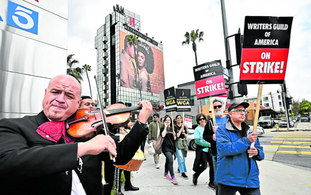 ‘ART CANNOT BE CREATED BY AMACHINE’ A mariachi bandperforms as members of the Writers Guild of America picket outside the Netflix office in Hollywood to protest the insistence of studios in tapping artificial intelligence. —AFP