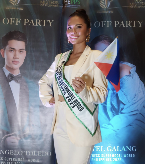 Miss Fitness Supermodel World second runner-up Kristel Galang poses with the poster of Mister Fitness Supermodel World third runner-up Michael Angelo Toledo. Photo from Armin P. Adina