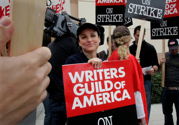 FILE PHOTO: Actress Julia Louis-Dreyfus (C), star of the Warner Bros. Television series 'The New Adventures of the Old Christine', and a member of the Screen Actors Guild carries a picket sign at Warner Bros. Studios in Burbank, California November 5, 2007 as she joins members of the Writers Guild America who are on strike against Hollywood film and television producers. REUTERS/Fred Prouser/File Photo