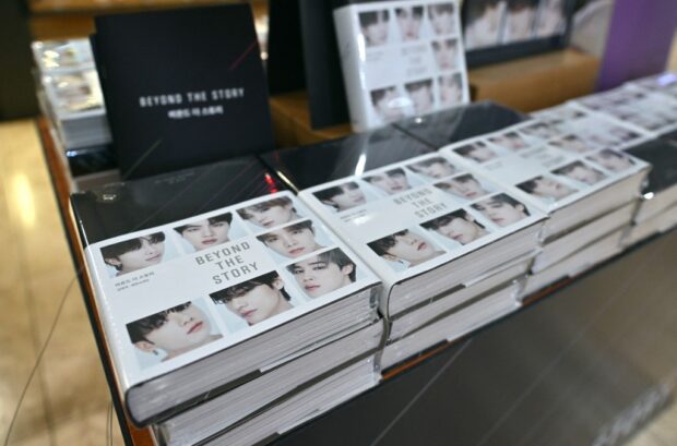 Copies of the BTS memoir titled "Beyond the Story: 10-Year Record of BTS" are seen on display at a bookstore in Seoul on July 9, 2023. K-pop megastars BTS released a hot-anticipated memoir in South Korea on July 9, to mark their 10th anniversary. (Photo by Jung Yeon-je / AFP)