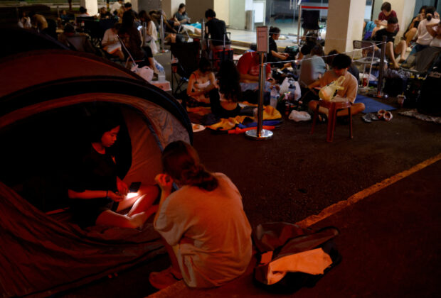 Sera, 14, and Eliza, 14, prepare to sleep in their tent as they queue overnight for Taylor Swift concert tickets outside a post office in Singapore, Singapore July 6, 2023. REUTERS/Edgar Su