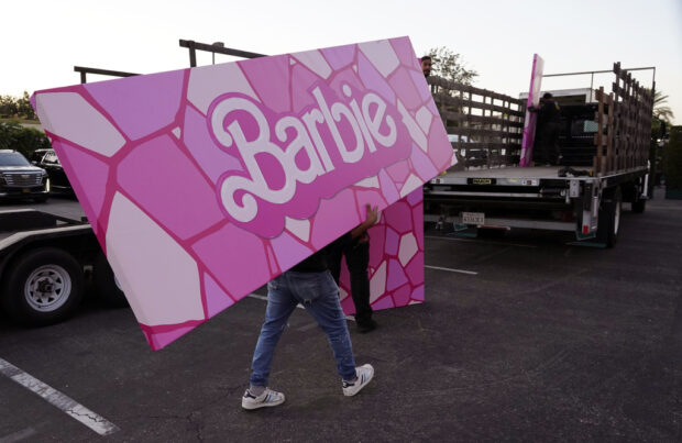 A crew member carries away a piece of "Barbie" set design after the premiere of the film, Sunday, July 9, 2023, at the Shrine Auditorium in Los Angeles. (AP Photo/Chris Pizzello)