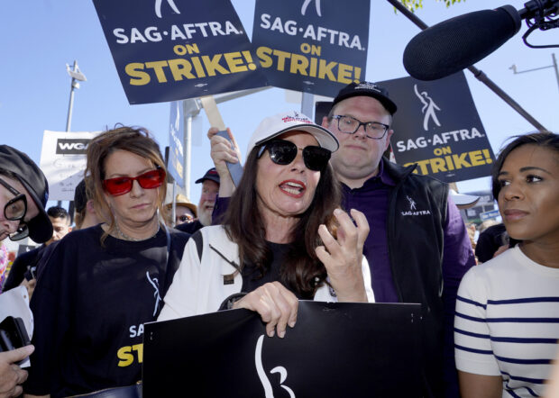 Actor Joely Fisher, from left, SAG-AFTRA president Fran Drescher and Duncan Crabtree-Ireland, SAG-AFTRA national executive director and chief negotiator, take part in a rally by striking writers and actors outside Netflix studio in Los Angeles on Friday, July 14, 2023. This marks the first day actors formally joined the picket lines, more than two months after screenwriters began striking in their bid to get better pay and working conditions. (AP Photo/Chris Pizzello)
