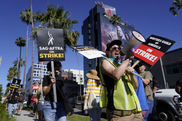 Striking writers and actors take part in a rally outside Netflix studio in Los Angeles on Friday, July 14, 2023. This marks the first day actors formally joined the picket lines, more than two months after screenwriters began striking in their bid to get better pay and working conditions. (AP Photo/Chris Pizzello)