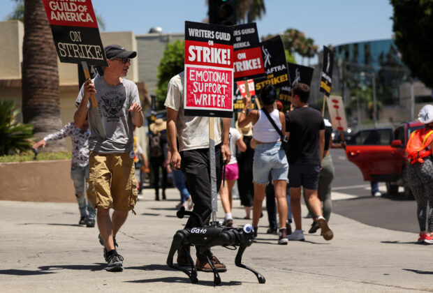 A robot dog named Gato moves with a sign on it as SAG-AFTRA actors and Writers Guild of America (WGA) writers walk the picket line during their ongoing strike outside Paramount Studios in Los Angeles, California, U.S., August 2, 2023. REUTERS/Mario Anzuoni