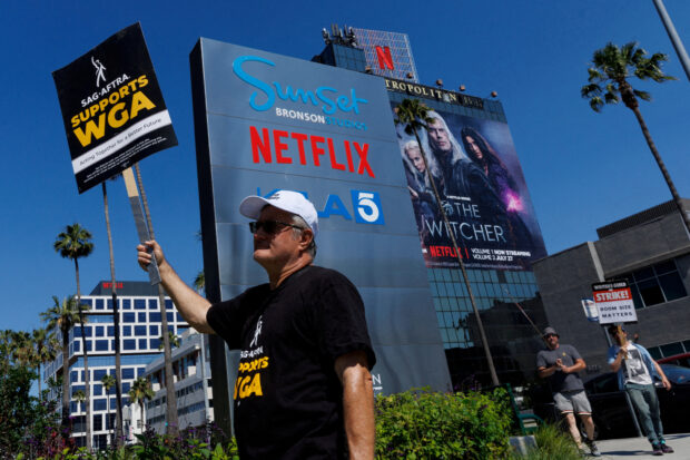 FILE PHOTO: Striking Writers Guild of America (WGA) members walk the picket line in front of Netflix offices in Los Angeles, California, U.S., July 12, 2023.   REUTERS/Mike Blake/File Photo
