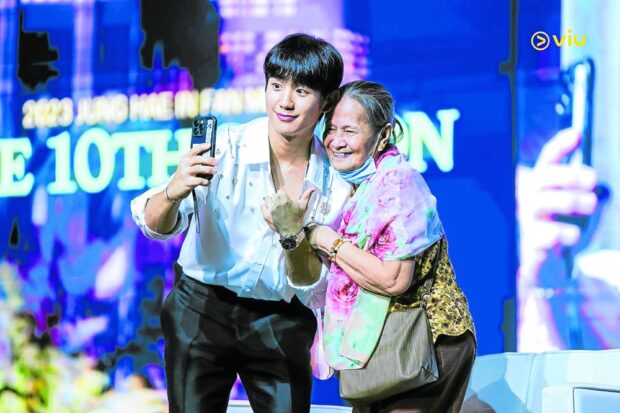 Jung Hae-in takes a selfie with a fan.