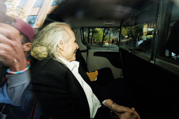 Seen through a police vehicle window, Canadian-Finnish fashion mogul Peter Nygard leaves a courthouse in Toronto, Ontario, on September 26, 2023. Held in prison since his arrest in December 2020, Nygard, 82, is being tried for alleged sexual assaults and forcible confinement involving several people between 1987 and 2006. He faces similar charges in Quebec and Manitoba, as well as extradition to the US, where he has been accused of raping dozens of women and girls, racketeering and trafficking. (Photo by Cole BURSTON / AFP)