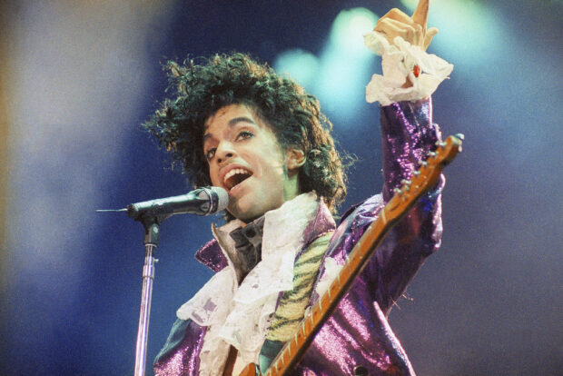 FILE - Prince performs at the Forum, Feb. 18, 1985, in Inglewood, Calif. Fans of Prince, who was known nearly as much for his extravagant wardrobe as for his chart-topping hits, will have a chance to bid on some of the late musician's sartorial splendor in an online auction running through Thursday, Nov. 16, 2023. (AP Photo/Liu Heung Shing, File)