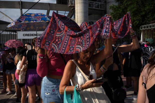 Fans of US singer Taylor Swift queue outside the Nilton Santos Olympic Stadium before Swift’s concert, “Taylor Swift: The Eras Tour”, amid a heat wave in Rio de Janeiro on November 18, 2023. American superstar Taylor Swift on Saturday was mourning the death of a 23-year-old fan during her first show in Brazil before a crowd of 60,000. The death occurred as much of central and southeastern Brazil has been suffering an unusually oppressive springtime heat wave. 