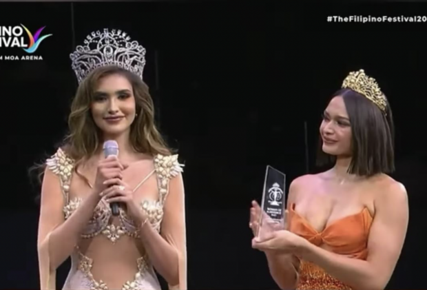 Pauline Amelinckx (right) receives the ‘Woman of Substance award from reigning Miss Supranational Andrea Aguilera./SCREENSHOT FROM MISS SUPRANATIONAL FACEBOOK VIDEO