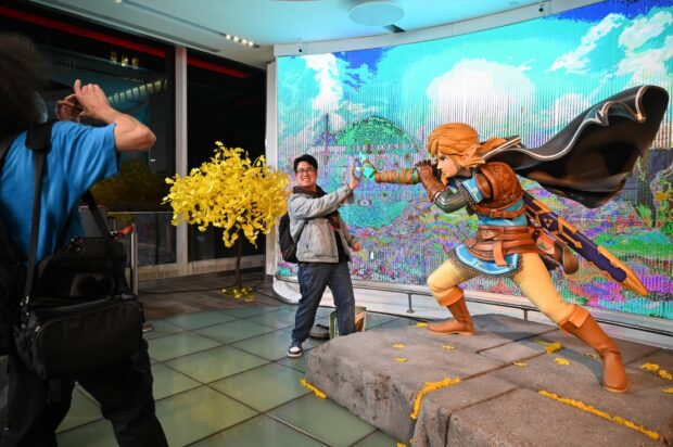 A customer poses for a photo with Zelda's character Link