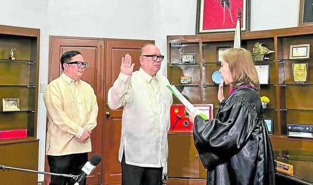 Reyes (center) duringhis oathtaking ceremony
with presiding judge
Mariflor Castillo of the
Court of Appeals