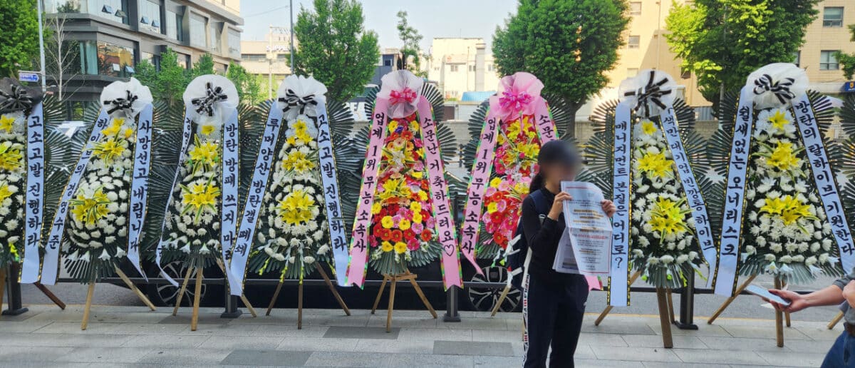 BTS' Army takes group action against Hybe for neglecting group  |  Wreaths of flowers with BTS fans' protesting messages against Hybe and BigHit Music are displayed in front of Hybe's headquarters in Yongsan-gu, Seoul, Friday. (The Korea Herald via Yonhap)