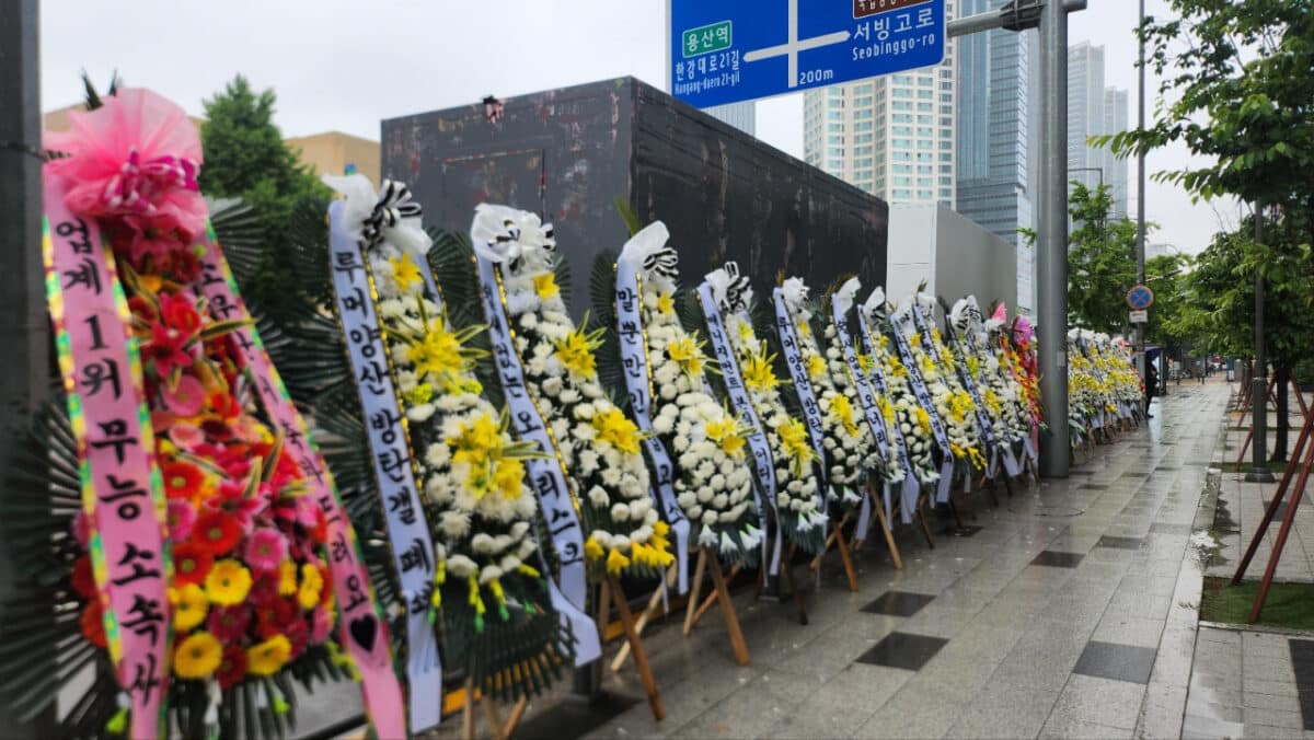 Flower wreaths with BTS fans' protesting messages against Hybe and Big Hit Music are displayed in front of Hybe's headquarters in Yongsan-gu, Seoul, Monday. Image: Lee Jung-youn/The Korea Herald
