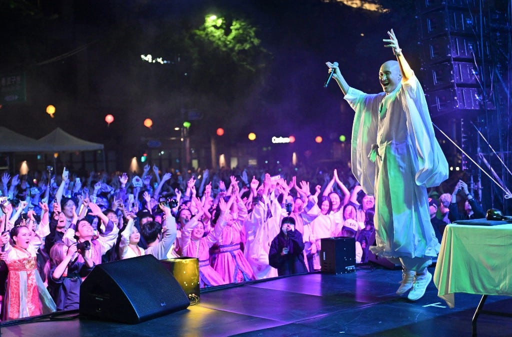 South Korean comedian Youn Sung-ho, known as NewJeansNim, wearing monk's robes performing during an electronic dance music party