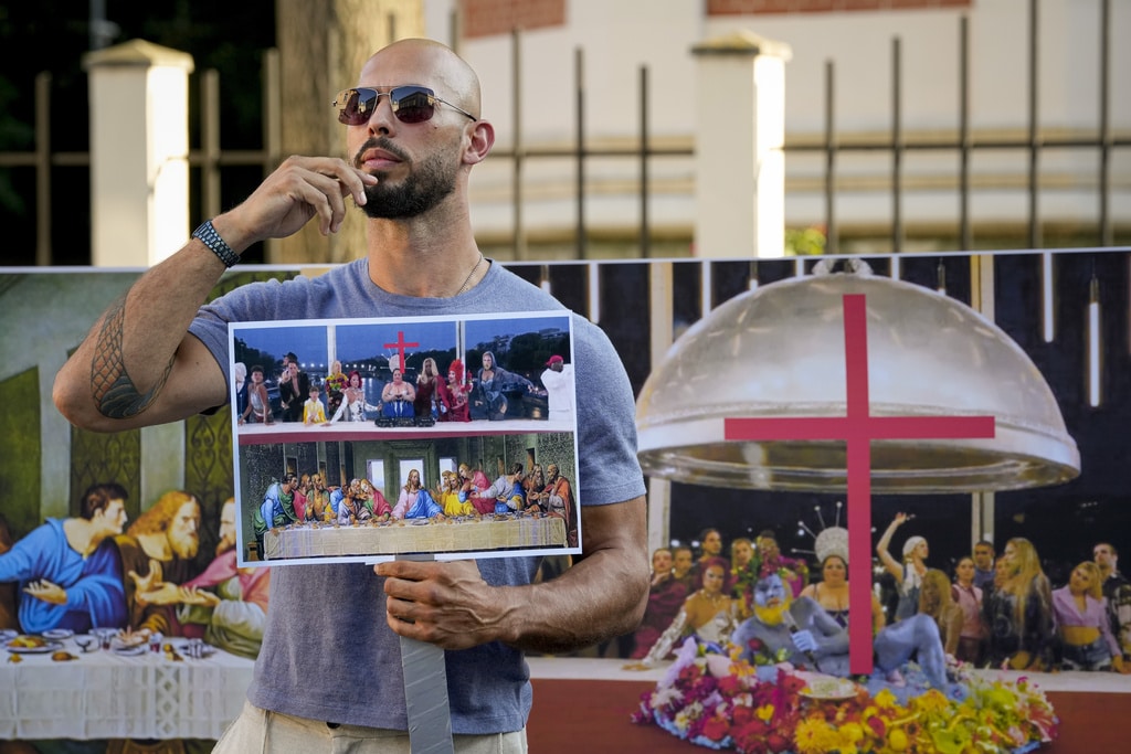 Social media influencer Andrew Tate gestures during a protest decrying a segment of the Paris Olympics opening ceremony, near the French Embassy in Bucharest, Romania, Sunday, July 28, 2024. Paris Olympics organizers apologized Sunday to anyone who was offended by a tableau that evoked Leonardo da Vinci's "The Last Supper" during the glamorous opening ceremony. The scene during Friday's ceremony featured DJ and producer Barbara Butch — an LGBTQ+ icon — flanked by drag artists and dancers. (AP Photo/Andreea Alexandru)