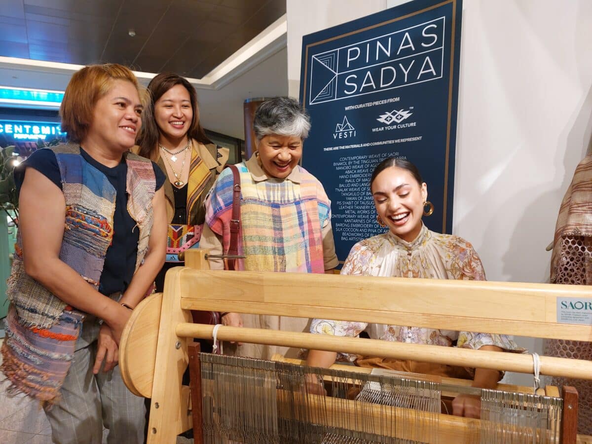 R’Bonney Gabriel (right) learns new techniques with the hand loom from Saori Philippines weaving trainer Becky Santiago (second from right) as weaver Jo Bernabe (left) and Vesti Bags designer Martha Rodriguez look on. Image: Armin P. Adina/INQUIRER.net