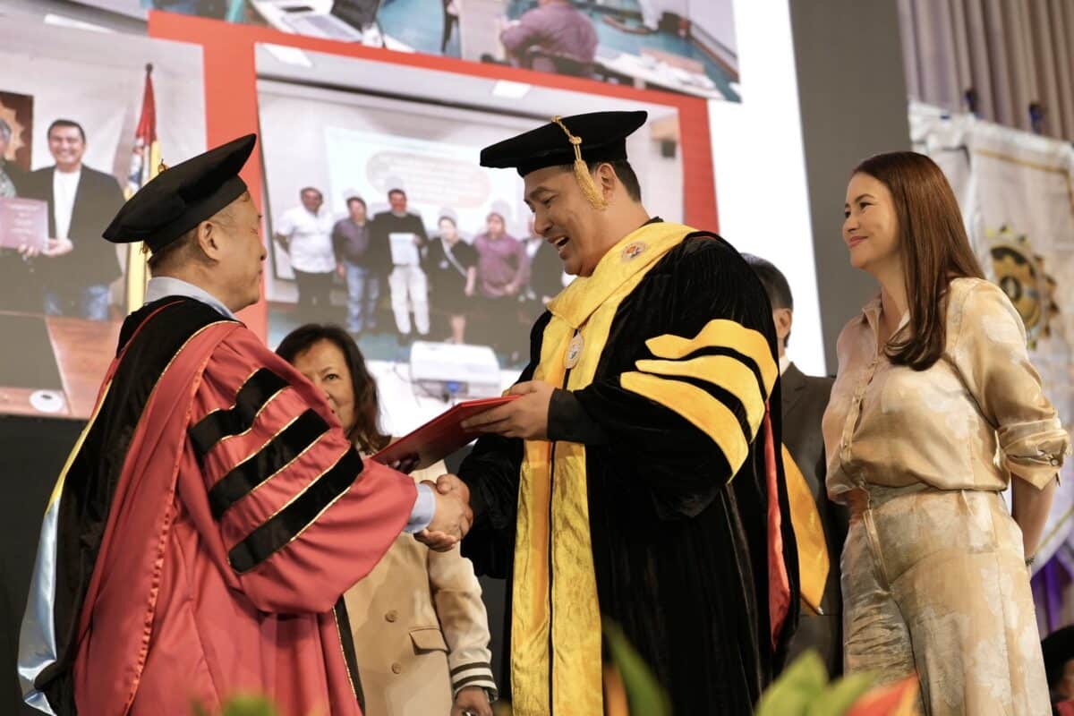 Mark Lapid receives his doctorate diploma as his wife Tanya Garcia looks on. Image from his office