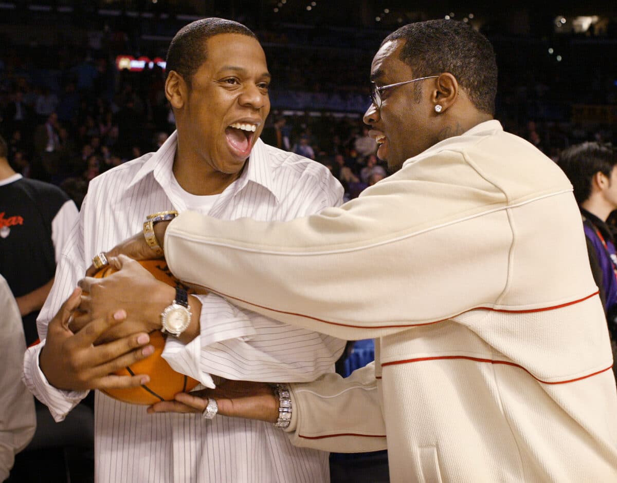 Rappers Jay-Z (left) and Sean "P. Diddy" Combs (right) joke around before the start of the NBA All-Star game in Los Angeles, Sunday, Feb. 15, 2004. Image: AP Photo/Kevork Djansezian