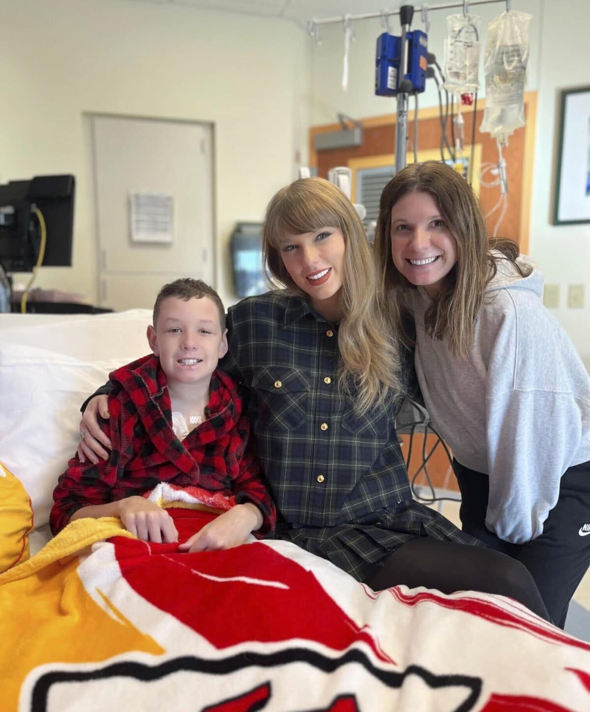 In this image provided by Cassie Thomas, Beckett Thomas, 13, who is a patient at Children's Mercy Hospital in Kansas City, Mo., and his mother Cassie Thomas (right) pose with Taylor Swift, Thursday, Dec. 12, 2024. Image: Cassie Thomas via AP