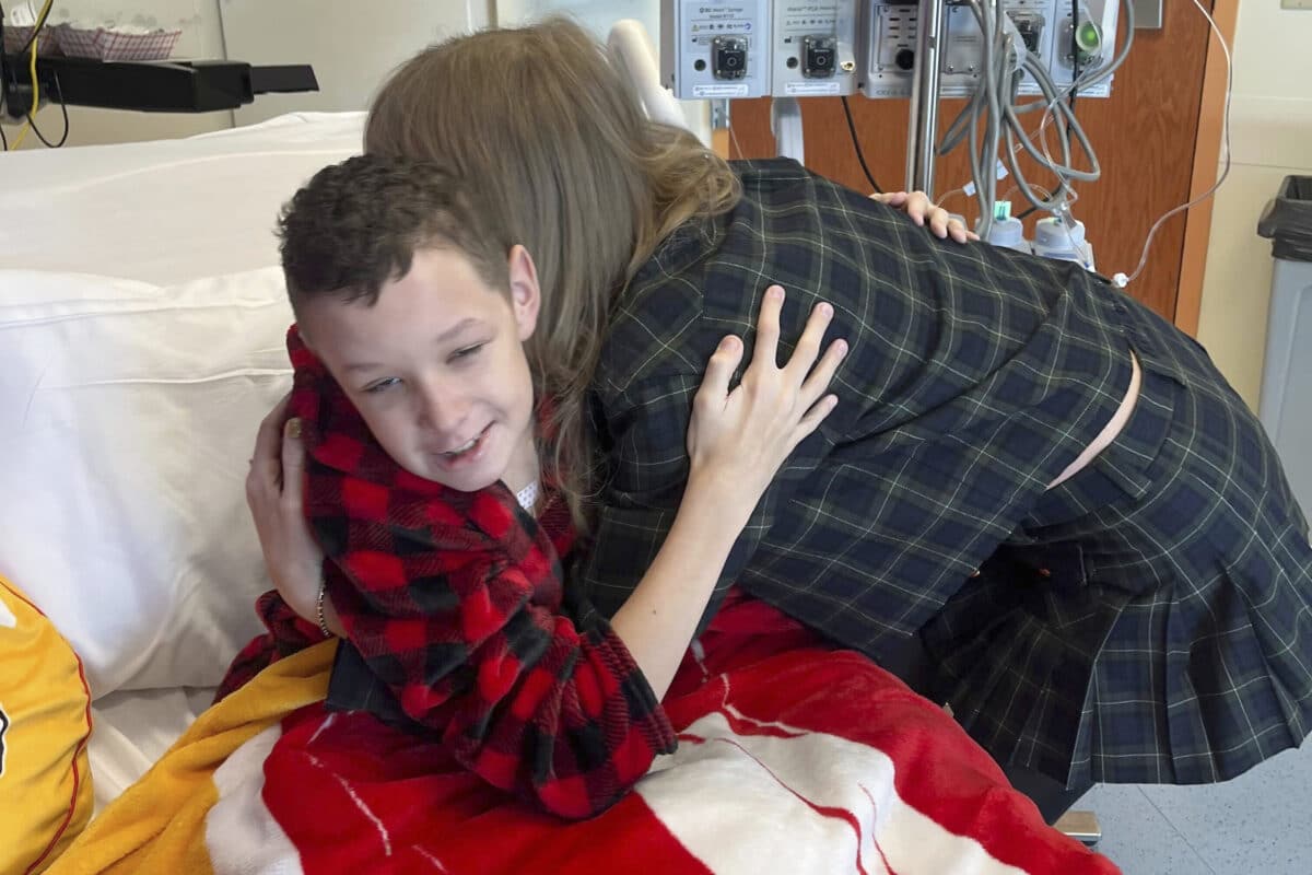 In this image provided by Cassie Thomas, Beckett Thomas, 13, who is a patient at Children's Mercy Hospital in Kansas City, Mo., is hugged by Taylor Swift, Thursday, Dec. 12, 2024. Image: Cassie Thomas via AP