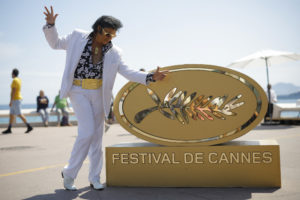 The 75th Cannes Film Festival - Cannes, France, May 25, 2022. Elvis Presley impersonator Eryl Prayer poses on the Croisette near an installation of a Palme d'Or symbol ahead of the screening of the film "Elvis" Out of Competition. REUTERS/Stephane Mahe